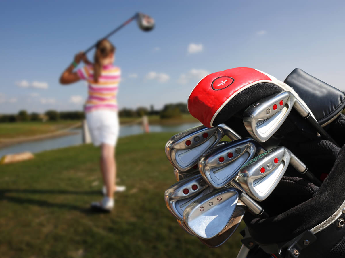 ゴルフバッグとゴルフをしている女性